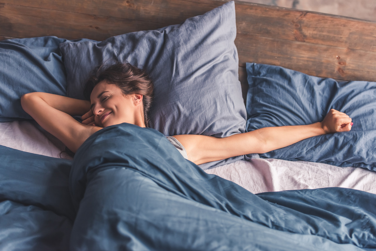 Kobieta wygodnie śpi na dębowym łóżku